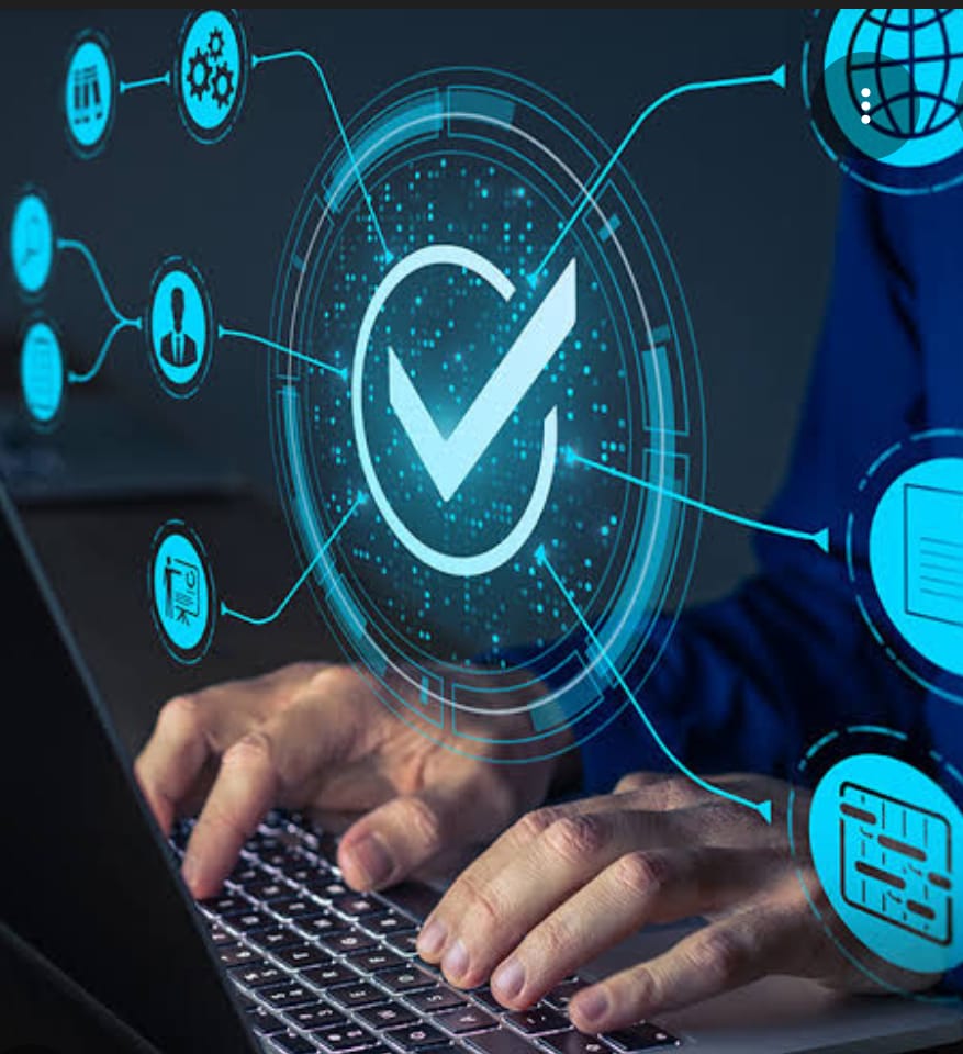 The image shows a person typing on a laptop keyboard with various digital icons and a large checkmark overlaying the scene.

- The person is wearing a blue shirt and typing on a laptop.
- A big glowing blue checkmark is in a circle at the center.
- There are several smaller blue icons around the checkmark connected by lines, including:
    - A globe
    - A document
    - A person icon
    - A gear/settings icon
    - A chart icon