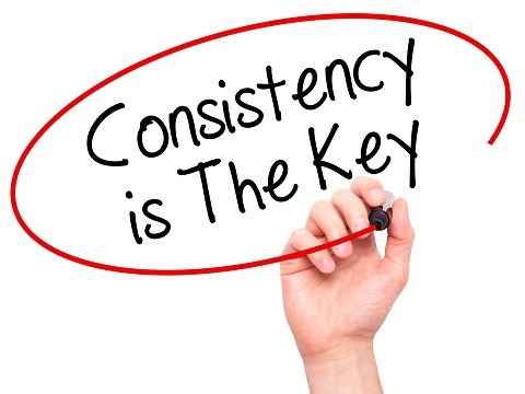This image shows a hand holding a marker, writing the text:

“Consistency is The Key”

The text is circled in red, emphasizing its importance.